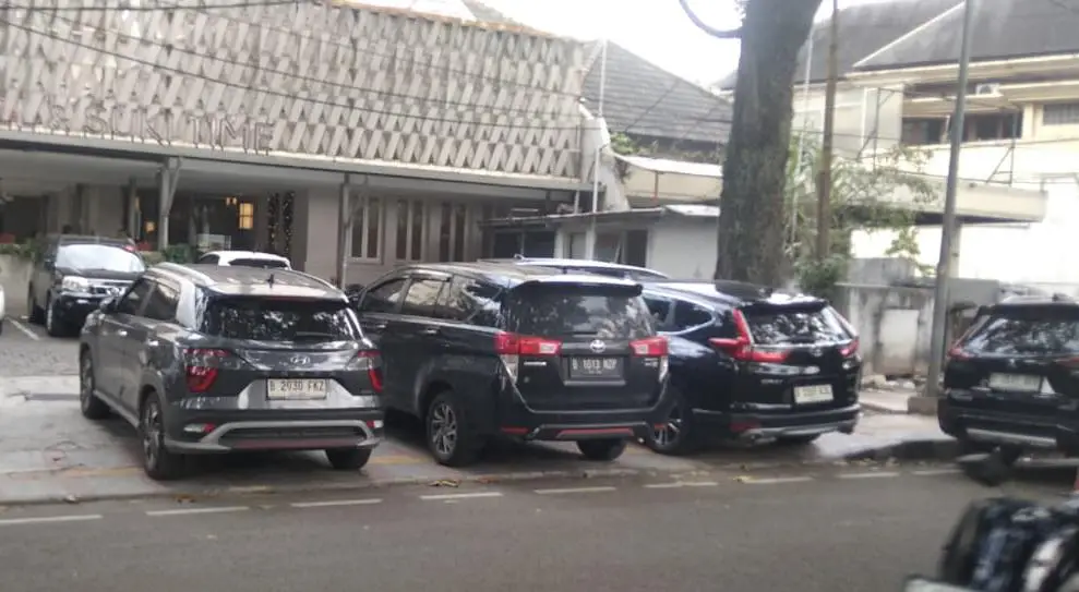 Photo of three cars illegally parked on a sidewalk in Bandung